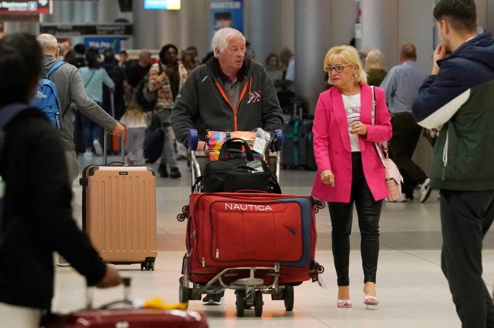 Travelers walk the American Airline concourse Monday, Nov. 21, 2022, in Miami, Fla. The holiday travel rush is already on, and it could spread out over more days than usual this year. Travel experts say the ability of many people to work remotely is letting them take off early for Thanksgiving or return home later. (AP Photo/Marta Lavandier)