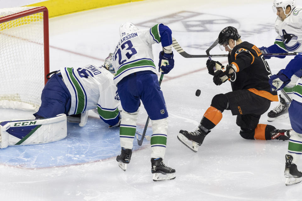 Vancouver Canucks goaltender Thatcher Demko (35) and defenseman Oliver Ekman-Larsson (23) block a shot on goal by Philadelphia Flyers right wing Wade Allison (57) during the first period of an NHL hockey game, Saturday, Oct. 15, 2022, in Philadelphia. (AP Photo/Laurence Kesterson)