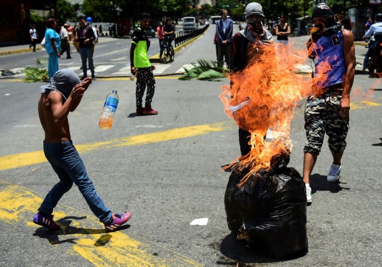 Anti-government activists demonstrate against Venezuelan President Nicolas Maduro at a barricade set up on a road in Caracas on August 8, 2017