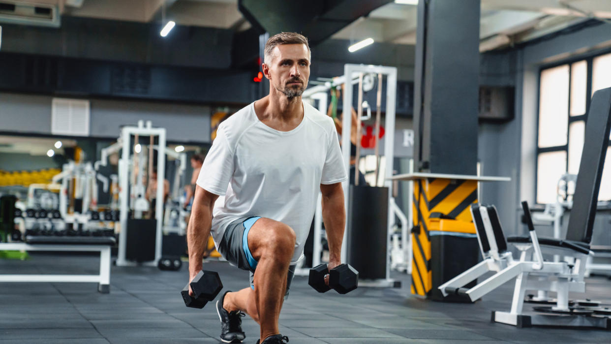  Man performing a dumbbell split squat 