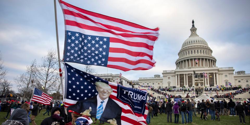 Pro-Trump protesters hold an American flag in front of the US Capitol.