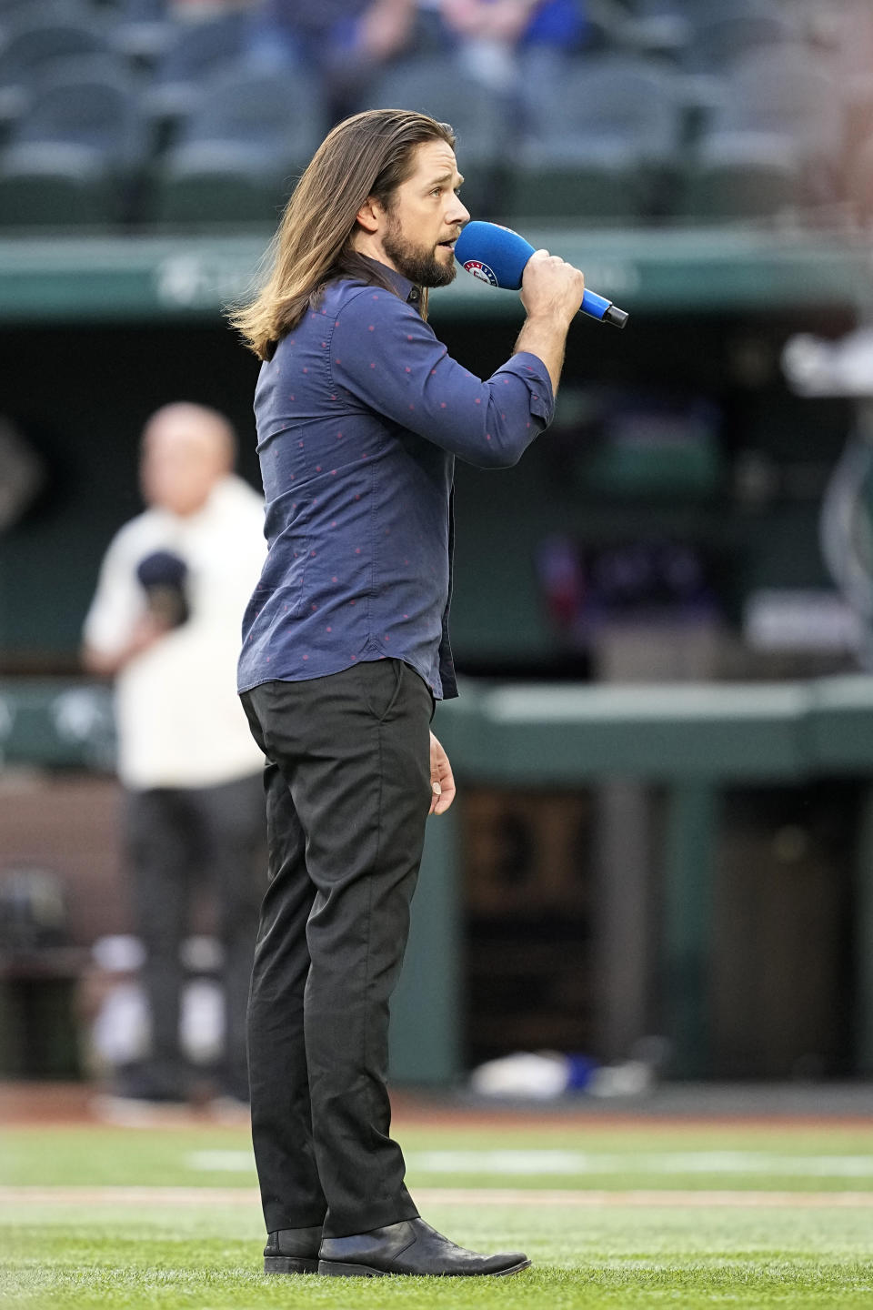 Tim Urban sings the national anthem before a baseball game between the Oakland Athletics and the Texas Rangers, Friday, April 21, 2023, in Arlington, Texas. (AP Photo/Tony Gutierrez)