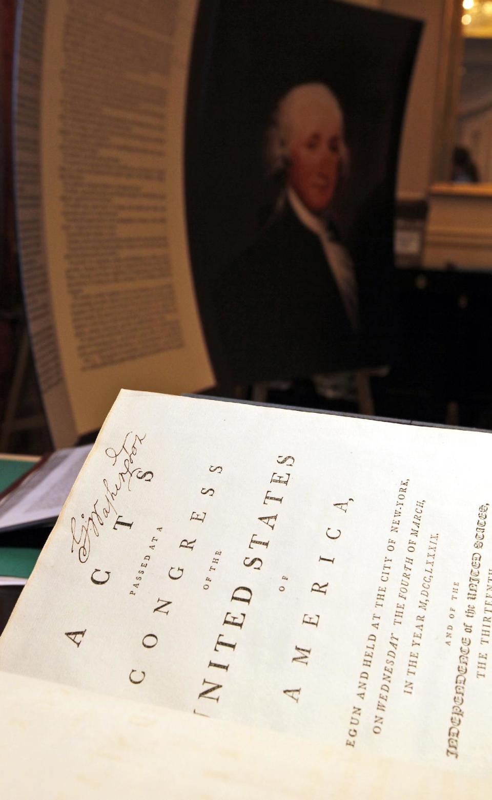 George Washington's signature is seen as Chris Coover, senior specialist for rare books & manuscripts at Christie's, shows President George Washington's personal copy of the Acts of the first Congress (1789), containing the U.S. Constitution and the proposed Bill of Rights, during a media availability, Tuesday, June 12, 2012, in Washington. The book will go on auction June 22nd and is expected to bring between $2-3 million. (AP Photo/Alex Brandon)