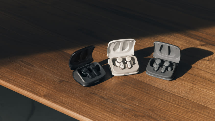 Three pairs of Audio Technica ATH-TWX7WH wireless earbuds on a wooden table. 