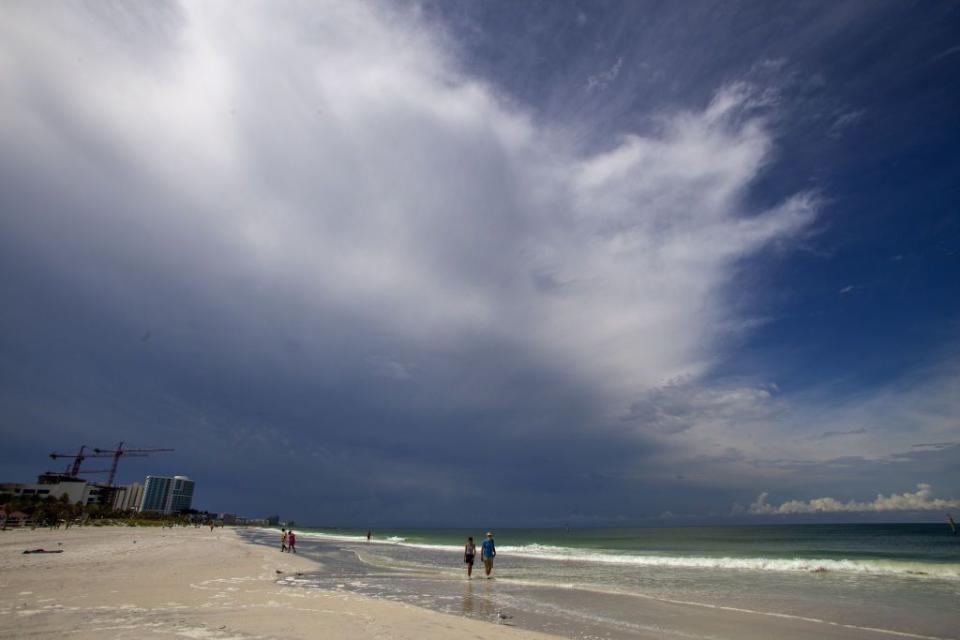 Residents on Clearwater Beach walk along the shore as Hurricane Idalia moved up the west coast of Florida on Tuesday.