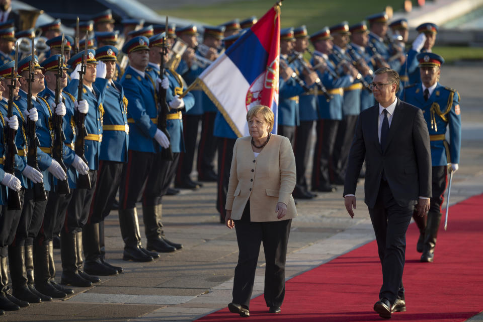 German Chancellor Angela Merkel, center, walks past honor guards while being accompanied by Serbia's president Aleksandar Vucic, front left, in Belgrade, Serbia, Monday, Sept. 13, 2021. Merkel is on a farewell tour of the Western Balkans, as she announced in 2018 that she wouldn't seek a fifth term as Germany's Chancellor. (AP Photo/Marko Drobnjakovic)