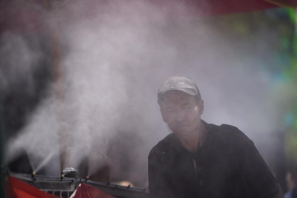 FILE - A person cools off in a mister along the Las Vegas Strip, Tuesday, June 4, 2024, in Las Vegas. Month after month, global temperatures are setting new records. (AP Photo/John Locher, File)