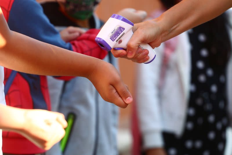 Pupils have their temperature checked before entering on the first day of school amid the coronavirus disease (COVID-19) outbreak in Madrid