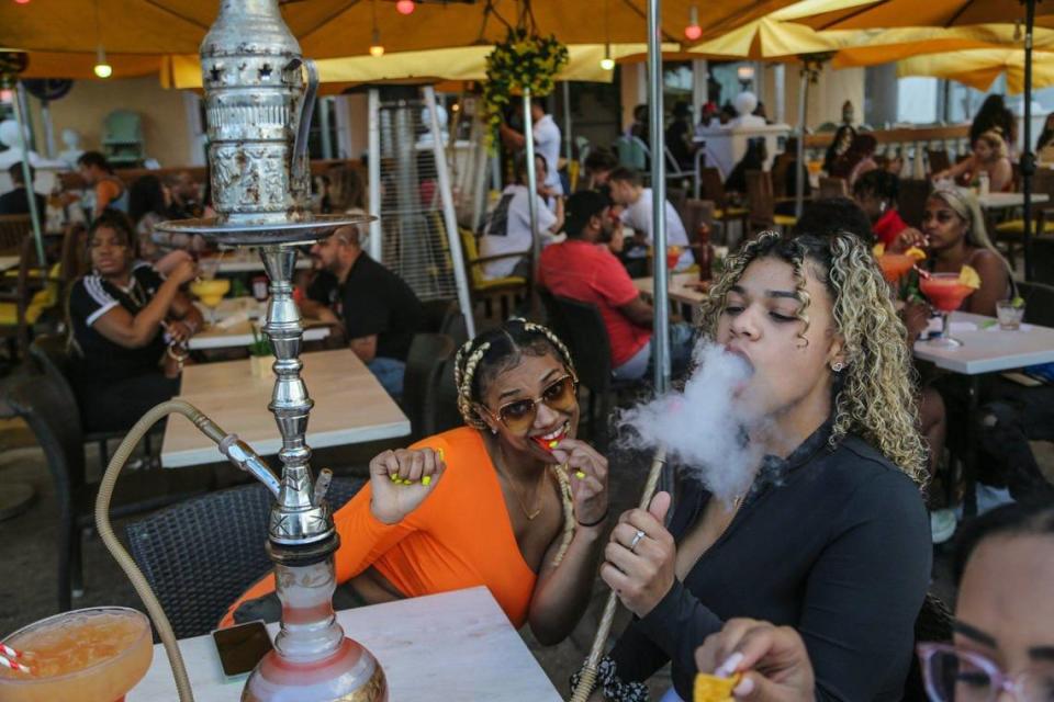 Despite the coronavirus, spring breakers Karsyn Mcleod, 21, and Zayasha Fowler, 21, spend time at outdoor dining and hookah bars along Ocean Drive on South Beach on Thursday, March 12, 2021.