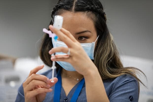 Nurse Brenda Lotakoun prepares a dose of the Moderna COVID-19 vaccine at a mobile clinic for employees of Apotex pharmaceuticals, in Toronto, on Apr. 13, 2021. (Evan Mitsui/CBC - image credit)