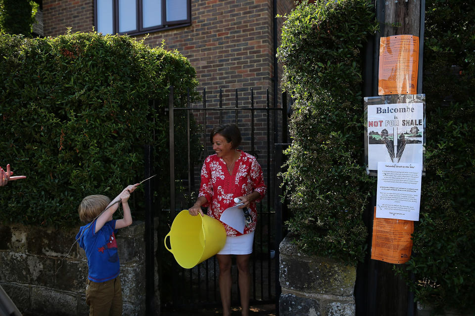 CRAWLEY, WEST SUSSEX - AUGUST 02:  A Balcombe resident speaks with a you boy outside her home close to a Fracking site operated by Cuadrilla Resources Ltd on August 2, 2013 in Crawley, West Sussex. Protesters continue to gather outside the Balcombe plant in West Sussex in opposition to the controversial method of extracting energy out of the ground called 'fracking'.  (Photo by Dan Kitwood/Getty Images)