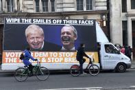 Cyclists pass a mobile anti-Brexit billboard at Trafalgar square in London, Tuesday, Dec. 10, 2019. Britain goes to the polls on Thursday, Dec. 12. (AP Photo/Srdjan Nedeljkovic)