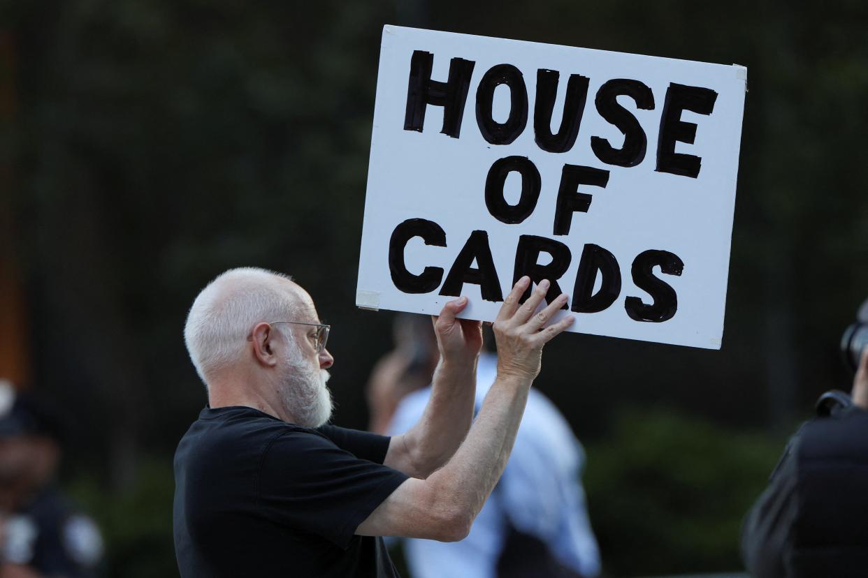 A demonstrator holds up a sign outside Trump Tower, on the day of the start of the trial of former U.S. President Donald Trump, his adult sons, the Trump Organization and others in a civil fraud case brought by state Attorney General Letitia James, in New York City, U.S., October 2, 2023 (REUTERS)