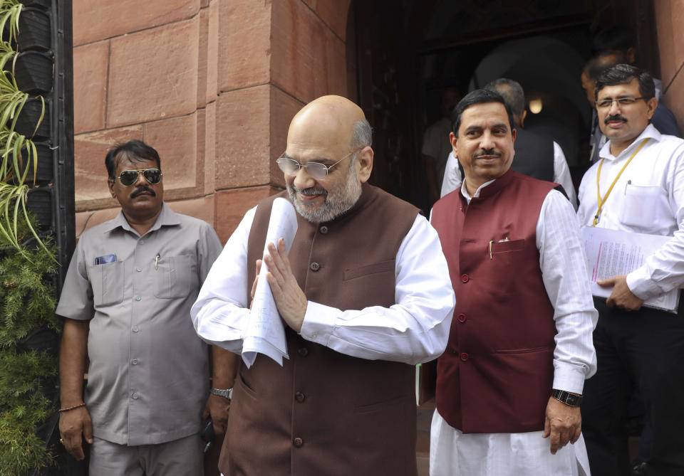 Indian Home Minister Amit Shah, center, greets as he arrives at the Parliament in New Delhi, India, Monday, Aug.5, 2019. India's government has proposed revoking disputed Kashmir's special constitutional status amid an uproar in Parliament. (AP Photo/Manish Swarup)