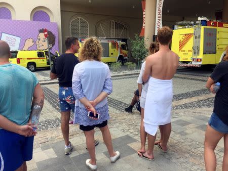 Evacuated guests stand outside the Movenpick hotel after a small fire broke out, in Dubai, United Arab Emirates August 7, 2017. REUTERS/Sylvia Westall