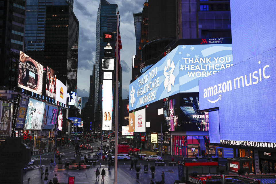 A screen displays a message thanking health care workers during the coronavirus outbreak, in a sparsely populated Times Square, Friday, March 20, 2020, in New York. New York Gov. Andrew Cuomo is ordering all workers in non-essential businesses to stay home and banning non-essential gatherings statewide. (AP Photo/John Minchillo)