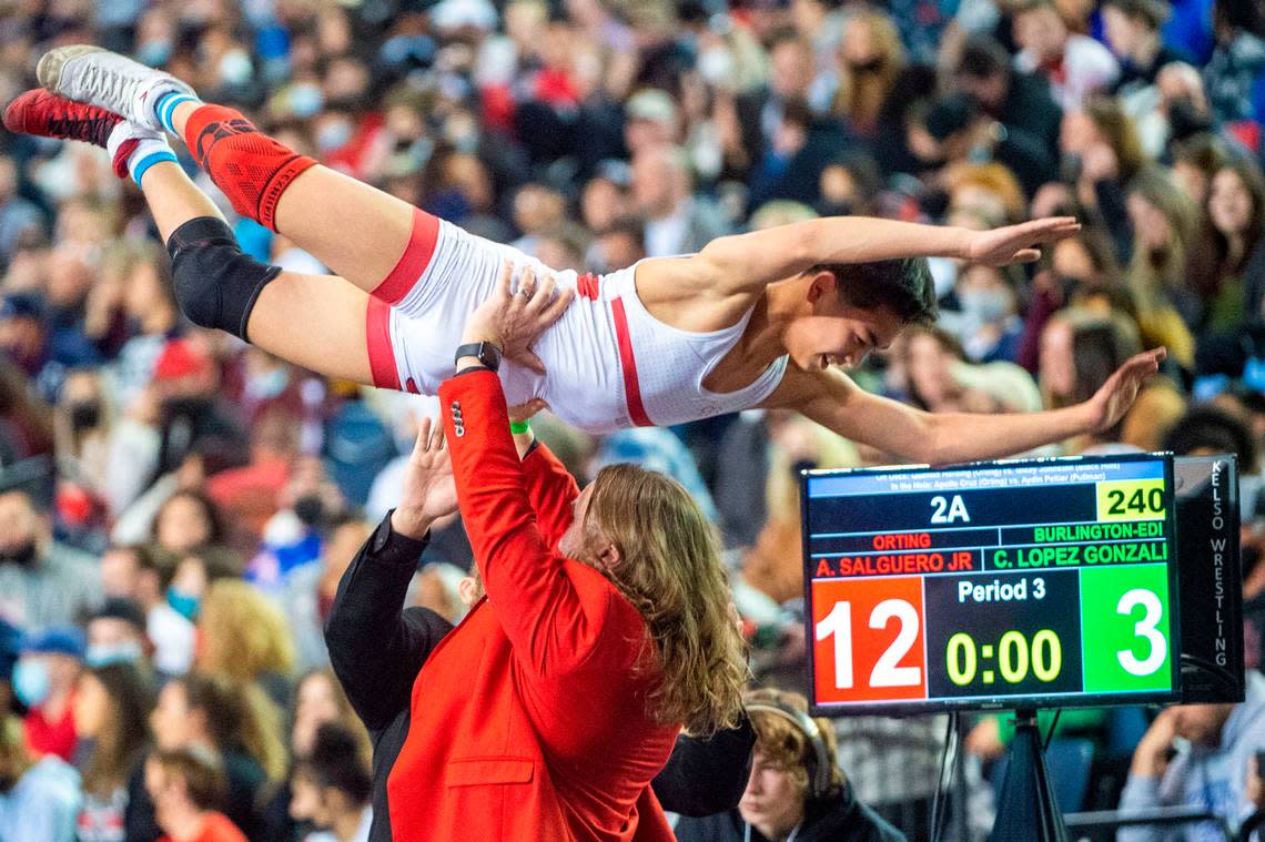 Orting head coach Jody Coleman lifts up Alan Salguero, Jr. after he beat Burlington Edison’s Chris Lopez Gonzales, 12-3, in the 106-pound 2A championship match at Mat Classic XXXIII on Saturday, Feb. 19, 2022, at the Tacoma Dome in Tacoma, Wash.