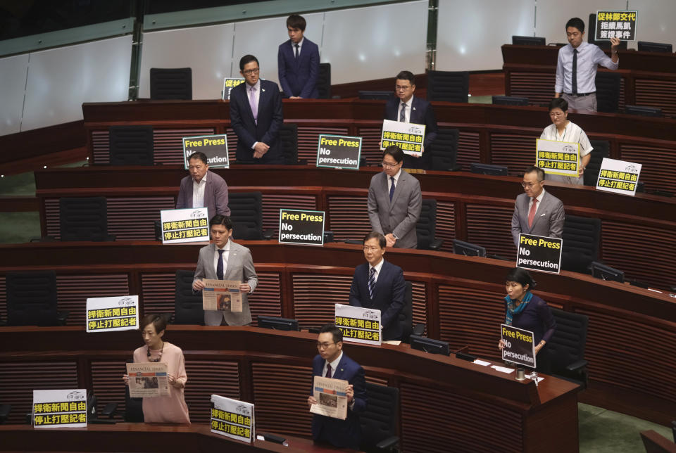 Pro-democracy lawmakers display placards "Press freedom persecution" to protest while Hong Kong Chief Executive Carrie Lam delivering her policy speech at the Legislative Council in Hong Kong Wednesday, Oct. 10, 2018. Hong Kong government has refused to renew the work visa of Victor Mallet, a senior editor of the Financial Times, in what human rights activists say is the latest sign of a deteriorating human rights situation in the semi-autonomous Chinese territory. (AP Photo/Vincent Yu)