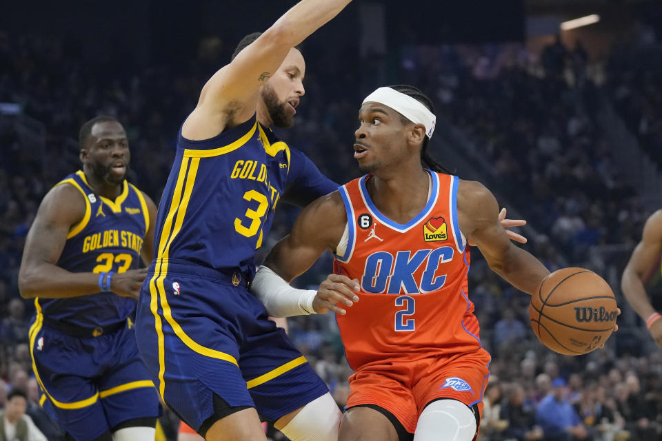 Oklahoma City Thunder guard Shai Gilgeous-Alexander (2) drives to the basket against Golden State Warriors guard Stephen Curry during the first half of an NBA basketball game in San Francisco, Tuesday, April 4, 2023. (AP Photo/Jeff Chiu)