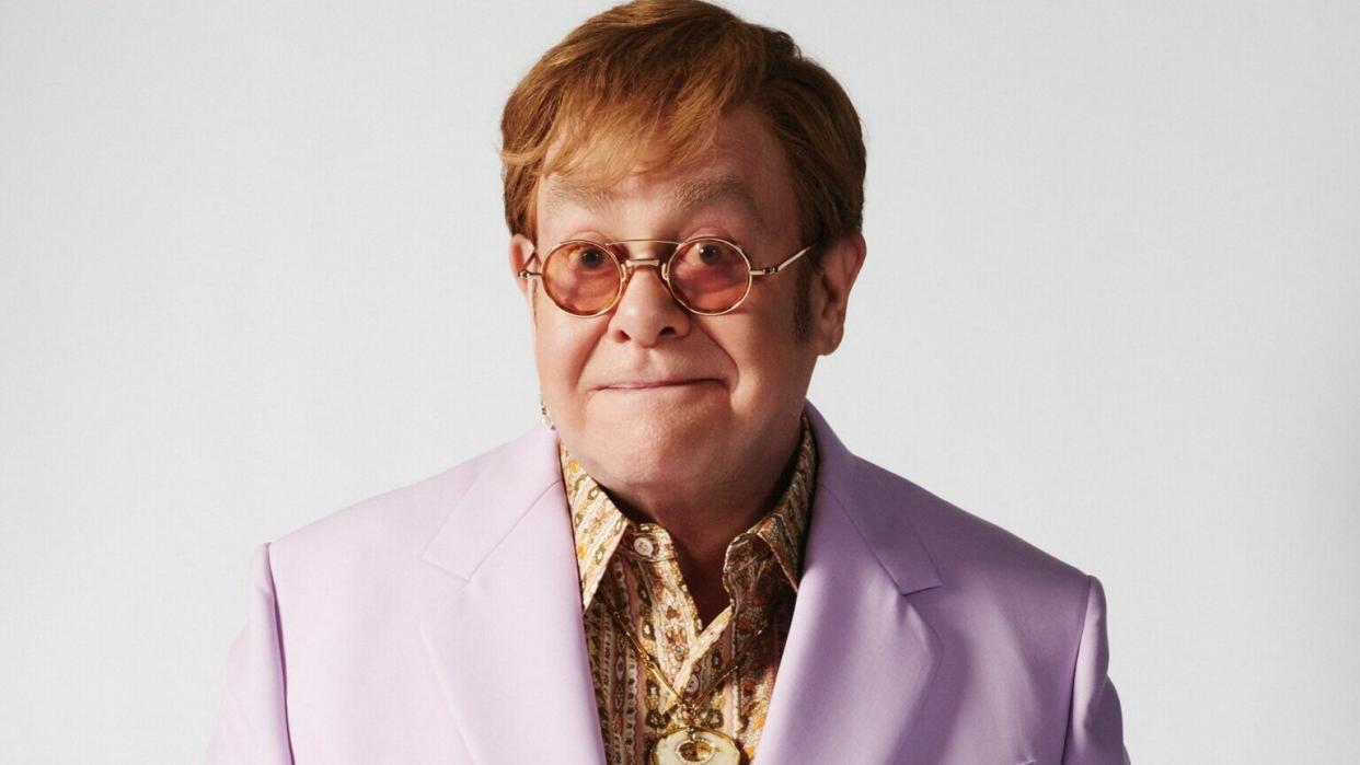 Elton John wearing a lavender suit