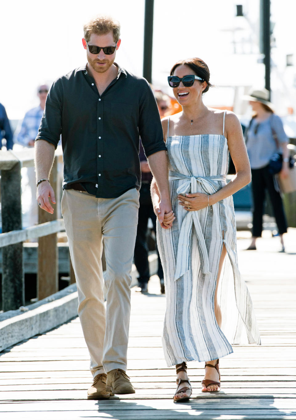 Meghan opts for a striped Reformation dress during her visit to Fraser Island [Photo via Getty Images]