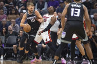 Sacramento Kings forward Domantas Sabonis (10) is guarded by Miami Heat center Bam Adebayo (13) during the first quarter of an NBA basketball game in Sacramento, Calif., Saturday, Oct. 29, 2022. (AP Photo/Randall Benton)