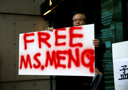 FILE PHOTO: Robert Long holds a sign outside the B.C. Supreme Court bail hearing of Huawei CFO Meng Wanzhou, who was held on an extradition warrant in Vancouver, British Columbia, Canada December 11, 2018. REUTERS/Lindsey Wasson/File Photo