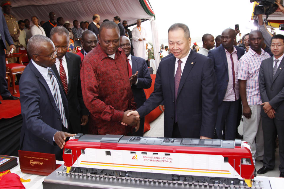 FILE - In this Tuesday, May 30, 2017 file photo, Kenya's President Uhuru Kenyatta, center-left, and chairman of China Railway Construction Corporation Chen Fenjian, center-right, shake hands next to a model of a train for the opening of the country's largest infrastructure project, a Chinese-backed railway, in Mombasa, Kenya. African leaders in 2020 are asking what China can do for them as the coronavirus pandemic threatens to destroy economies across a continent where Beijing is both the top trading partner and top lender. (AP Photo/Khalil Senosi, File)