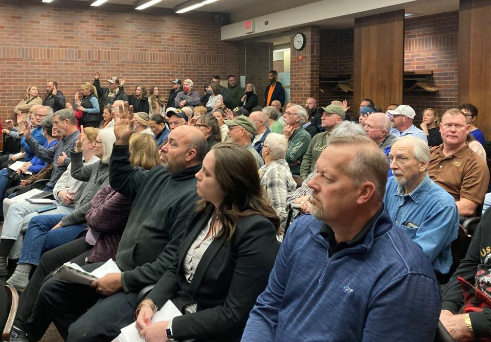 Community members hoping to voice their opinion on the special use permit requested by Republic Services raise their right hand to be sworn in prior to public comment at the Board of Zoning Appeals meeting on Thursday, Dec. 15, 2022, at the Evansville Civic Center.