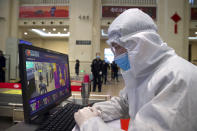 A worker in a protective suit monitors a temperature scanner at Hankou train station after of the resumption of train services in Wuhan in central China's Hubei Province, Wednesday, April 8, 2020. After 11 weeks of lockdown, the first train departed Wednesday morning from a re-opened Wuhan, the origin point for the coronavirus pandemic, as residents once again were allowed to travel in and out of the sprawling central Chinese city. (AP Photo/Ng Han Guan)