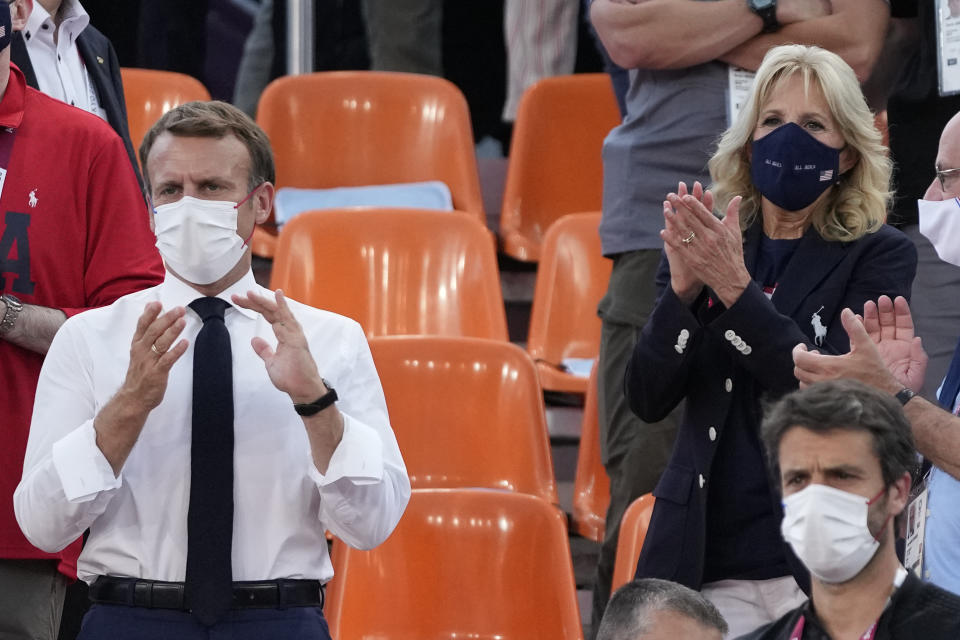 French President Emmanuel Macron, left, and United States First Lady Jill Biden, right, applaud as they watch a women's 3-on-3 basketball game between the United States and France at the 2020 Summer Olympics, Saturday, July 24, 2021, in Tokyo, Japan. (AP Photo/Jeff Roberson)