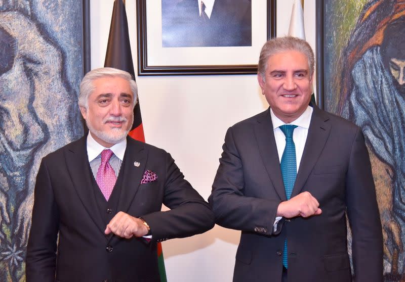 Pakistan's Foreign Minister Shah Mahmood Qureshi bumps elbows with the head of the Afghanistan's peace council, Abdullah Abdullah, upon his arrival at the Ministry of Foreign Affairs (MOFA) office in Islamabad