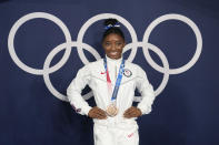 FILE - Simone Biles, of the United States, poses wearing her bronze medal from balance beam competition during artistic gymnastics at the 2020 Summer Olympics, Aug. 3, 2021, in Tokyo, Japan. President Joe Biden will present the nation's highest civilian honor, the Presidential Medal of Freedom, to 17 people, at the White House next week. (AP Photo/Natacha Pisarenko, File)