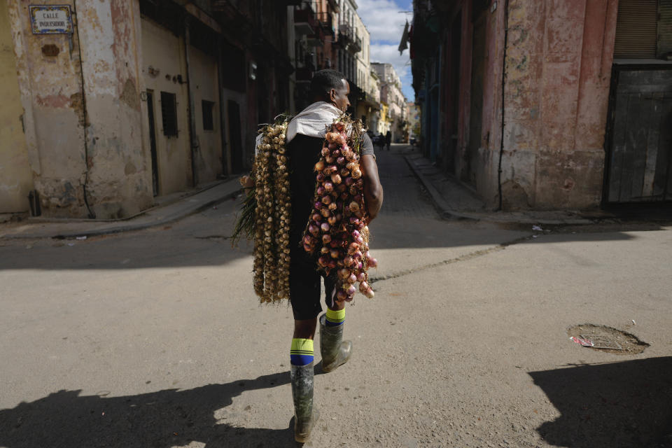 Un vendedor recorre las calles de La Habana vieja con cebollas y ajos, en Cuba, el 31 de enero de 2024. (AP Foto/Ramón Espinosa)
