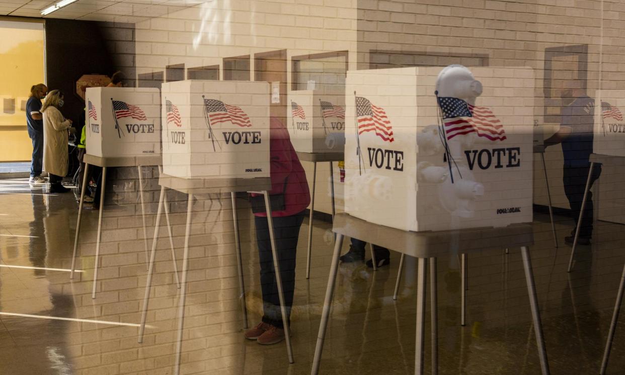 <span>People cast ballots at an early voting polling location for the 2020 presidential elections in Adel, Iowa.</span><span>Photograph: Bloomberg/Getty Images</span>