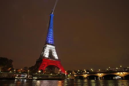 The Eiffel Tower is lit with the blue, white and red colours of the French flag in Paris, France, November 16, 2015, to pay tribute to the victims of a series of deadly attacks on Friday in the French capital. REUTERS/Benoit Tessier