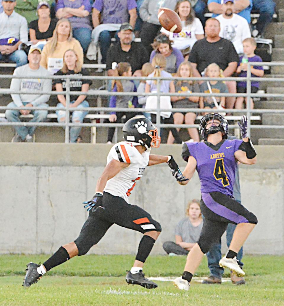 Watertown's Drew Denzer gets ready to haul in a long pass against Huron's Quinston Luellman Clark during their Eastern South Dakota Conference football game Friday night at Watertown Stadium. The Arrows won 34-19.