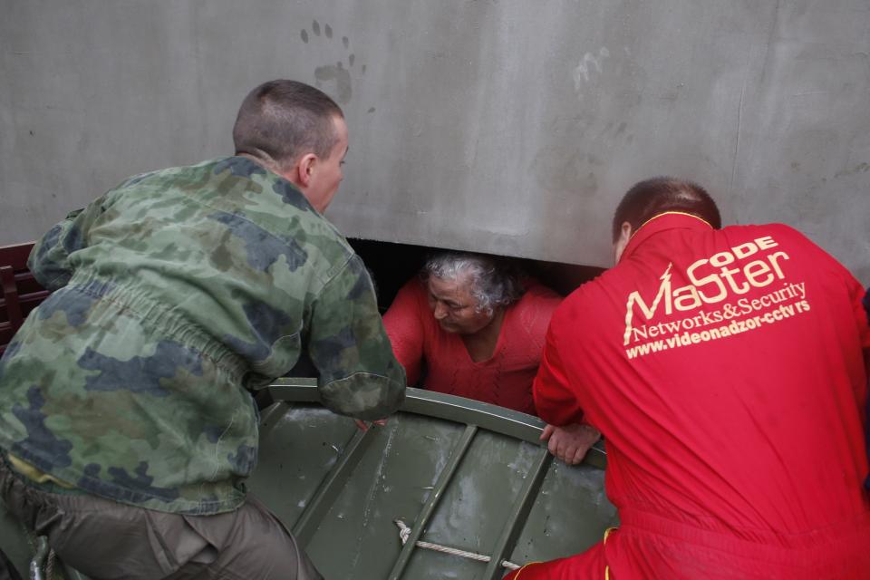 Serbian army soldiers evacuate a woman from a flooded house in the town of Obrenovac, east from Belgrade May 16, 2014. (REUTERS/Marko Djurica)