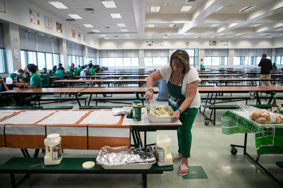Stephanie Sirianni mixes her famous salad before serving the pre-game meal to the Fort Myers High football players on Thursday, Oct. 19, 2023, at Fort Myers High School.