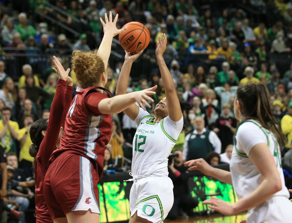 Oregon's Te-Hina Paopao, center, tries unsuccessfully to get off a last second shot against Washington State in overtime Sunday, Jan. 15, 2022, at Matthew Knight Arena in Eugene, Ore.
