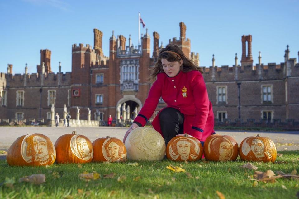 Palace host Aurora Heimsath with pumpkins bearing the face of Henry VIII and his wives (Steve Parsons/PA) (PA Wire)