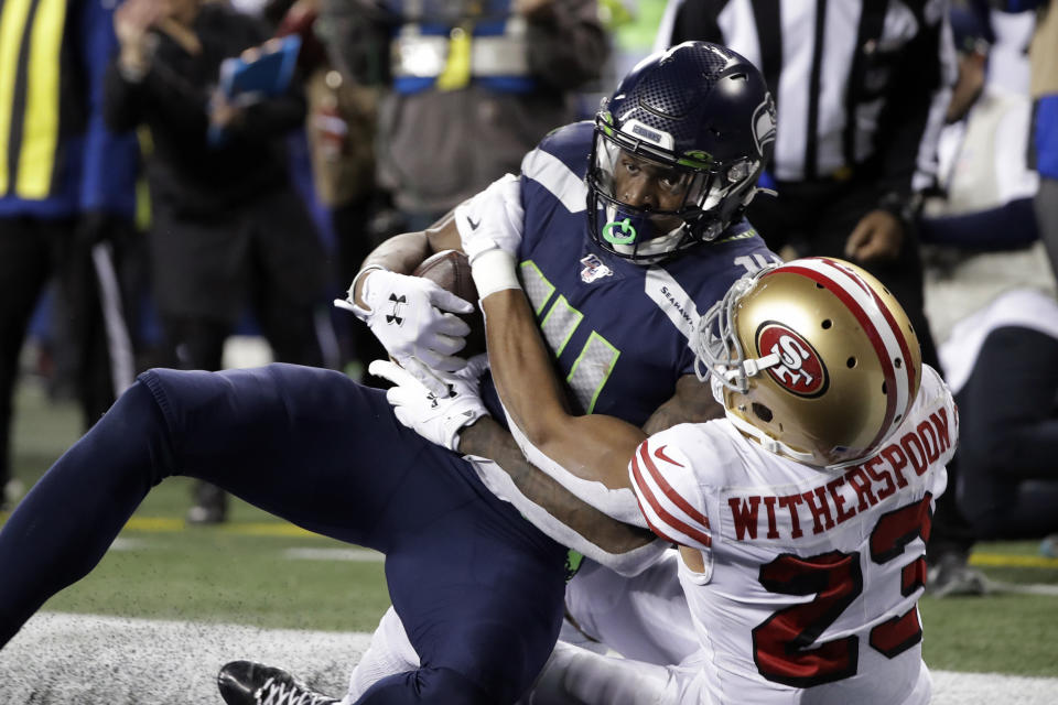Seattle Seahawks' DK Metcalf, left, is wrapped up by San Francisco 49ers' Ahkello Witherspoon as he comes down with a touchdown reception in the end zone during the second half of an NFL football game, Sunday, Dec. 29, 2019, in Seattle. (AP Photo/Ted S. Warren)