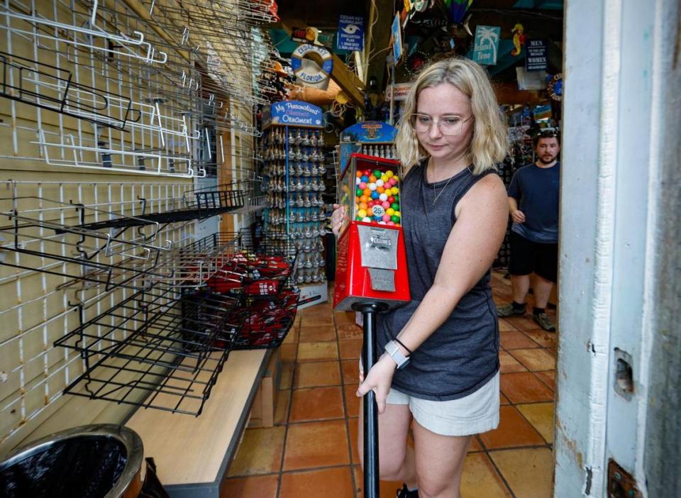 Carol Carlin, co-owner of Island Trading Post carries out her father’s bubble gum machine displayed at the store as she and her family prepare to evacuate for Hurricane Idalia in Cedar Key, Florida on Tuesday, August 29, 2023.
