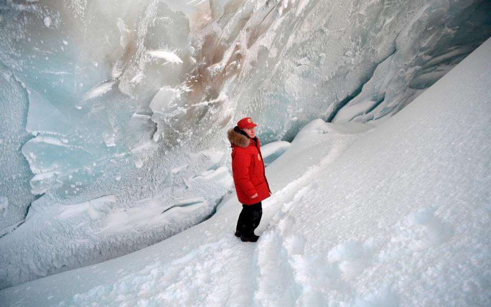 Russian President Vladimir Putin inspects a cavity in a glacier on the Arctic Franz Josef Land archipelago in Arctic Russia - Credit: Kremlin Pool Photo/AP