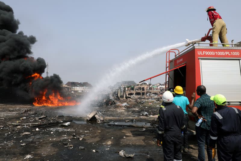 A firefighter douses the fire at the scene of a pipeline explosion at Abule-Ado in Lagos