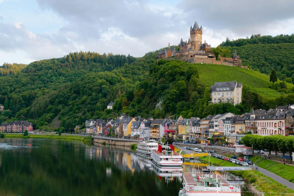 These top cities of Europe should be on traveler’s bucket lists. Pictured: a lake side castle in a lush forest seemingly in Europe