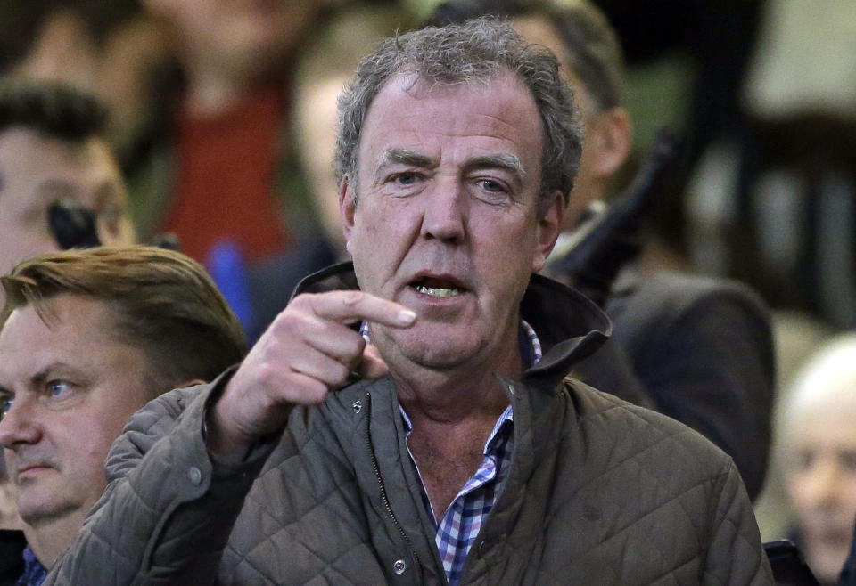 FILE - In this Wednesday, March 11, 2015 file photo TV host Jeremy Clarkson gestures as he takes his place in the stands before the Champions League round of 16 second leg soccer match between Chelsea and Paris Saint Germain at Stamford Bridge stadium in London. Clarkson, the former host of hit BBC auto show "Top Gear," has apologized and paid an undisclosed sum to a producer he punched in an off-set altercation it was reported on Wednesday, Feb. 24, 2016. Clarkson was fired in March 2015 after hitting Oisin Tymon during a dispute at the end of a day's filming. (AP Photo/Matt Dunham, File)