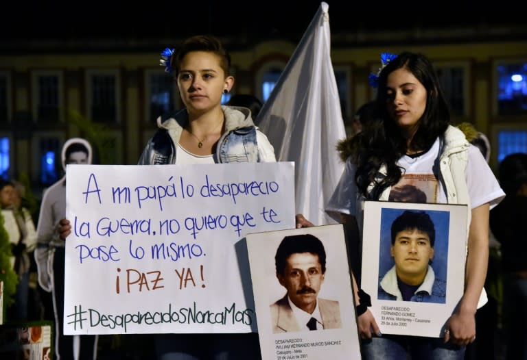 Two young women hold signs during a march for peace in Bogota, on October 20, 2016