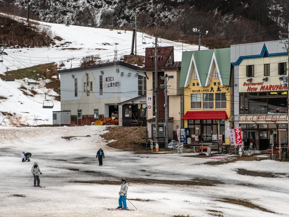 Skiers pause near restaurants at a ski resort that has had to close a number of slopes because of a lack of snow in Minamiuonuma, Japan. Getty Images