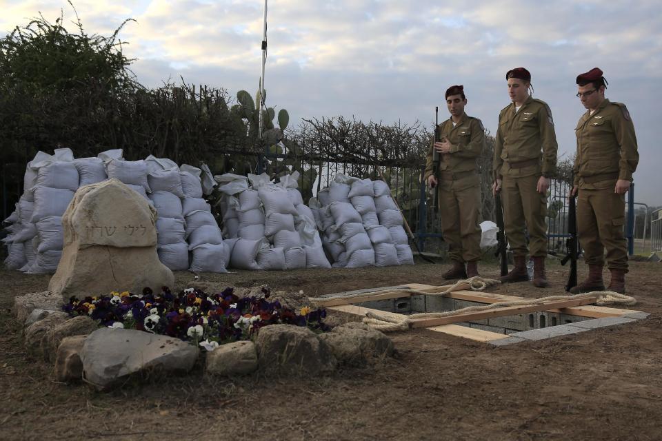 Israeli soldiers from a paratroopers unit rehearse at the grave site for late Israeli Prime Minister Ariel Sharon, who will be buried next to his wife, outside his ranch in Havat Hashikmim, southern Israel, Sunday, Jan. 12, 2014. A state memorial is planned for Monday with the participation of Israeli and world leaders, the prime minister's office said. (AP Photo/Tsafrir Abayov)